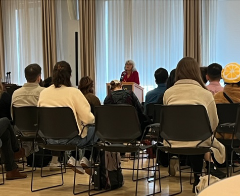 Louise Halfe at a podium, and students in chairs listening