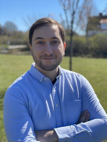man standing outdoors with his arms crossed