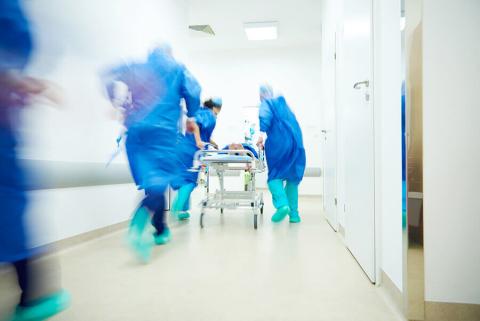 stock photos of hospital workers in scrubs escorting a gurney