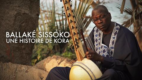  Ballaké Sissoko posing outdoors with a 26-string kora