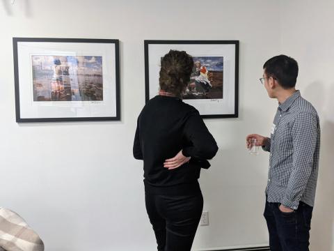 two people looking at a photo on the wall