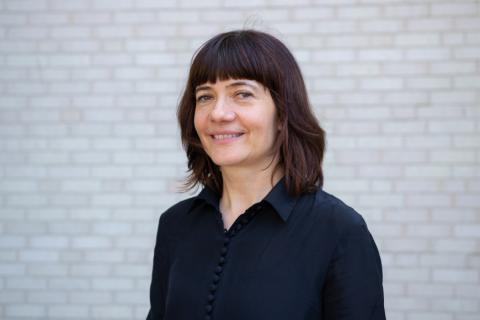 Bettina Stoetzer standing in front of a white brick wall