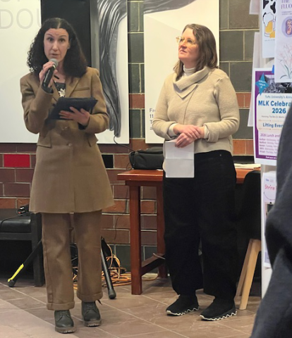 Silvia Bottinelli speaking into the microphone while Emily Gephart stands nearby