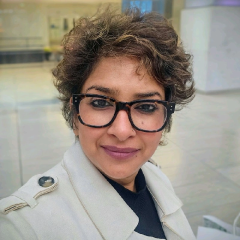 Namrata jain sitting in a room with glass cases and a white pillar