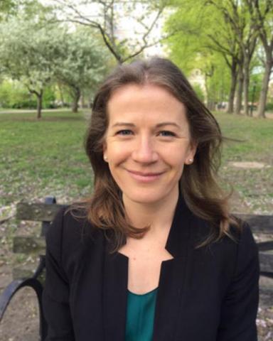 Sarah Mass sitting on a bench in a park