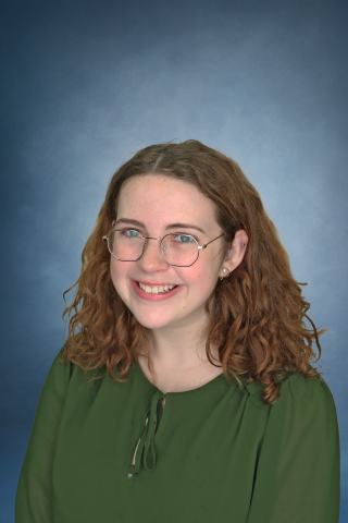 Haley Mullen in front of a blue background, smiling