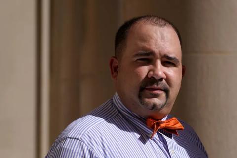 David Shane Lowry standing outdoors wearing a blue shirt and orange bowtie