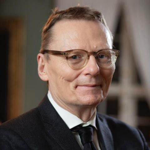 James Robinson in a suit with a window and door in the background