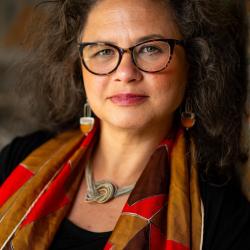 headshot of Kendra field, wearing a red and brown scarf