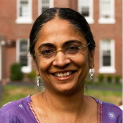 Modhumita in purple dress with buildings behind her