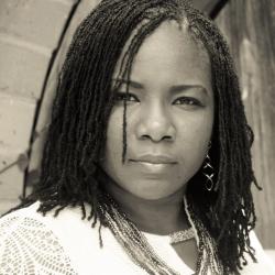 Charrise Barron in black and white with a brick background