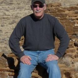 Raymond Silverman sitting on a rock in a desert