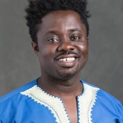 Emmanuel Poku in a blue shirt with a grey background