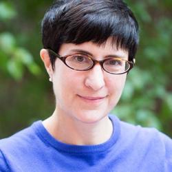 Heather Nathans in a blue shirt, with leaves in the background