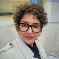 Namrata jain sitting in a room with glass cases and a white pillar