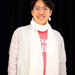 Wenxuan Xue wearing a white jacket and white scarf in front of a black background