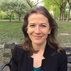 Sarah Mass sitting on a bench in a park