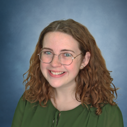 Haley Mullen in front of a blue background, smiling