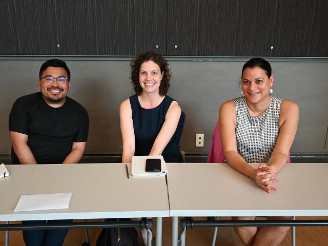 man and two women at table, smiling at camera