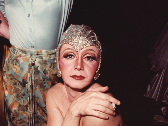 drag queen in headdress posing for photo