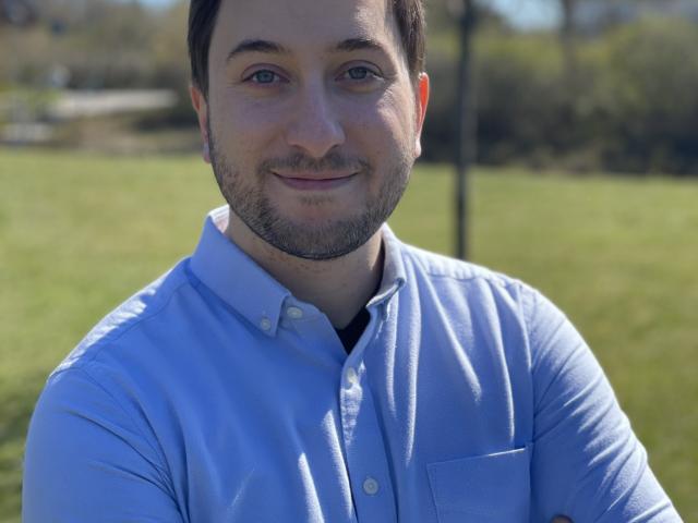 man standing outdoors with his arms crossed