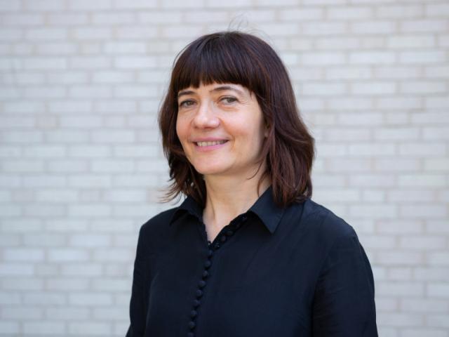 Bettina Stoetzer standing in front of a white brick wall