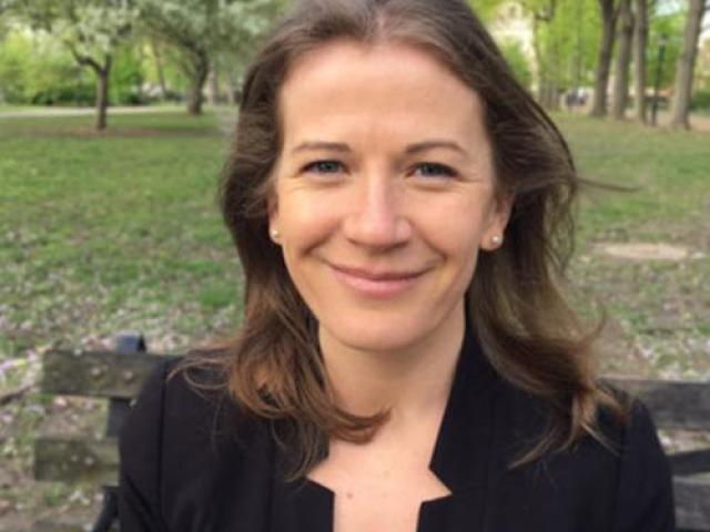 Sarah Mass sitting on a bench in a park