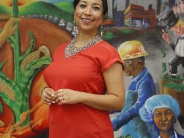 Magaly Licoli standing in front of a colorful mural
